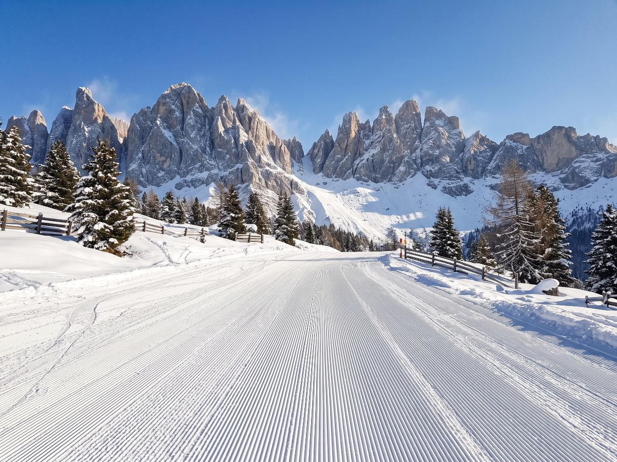 Uređena skijaška staza ispod stenovitih vrhova Dolomita (AI prikaz)
