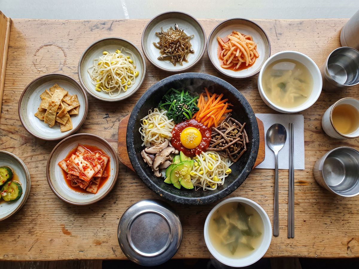 Bibimbap i korejski prilozi na stolu (AI prikaz)